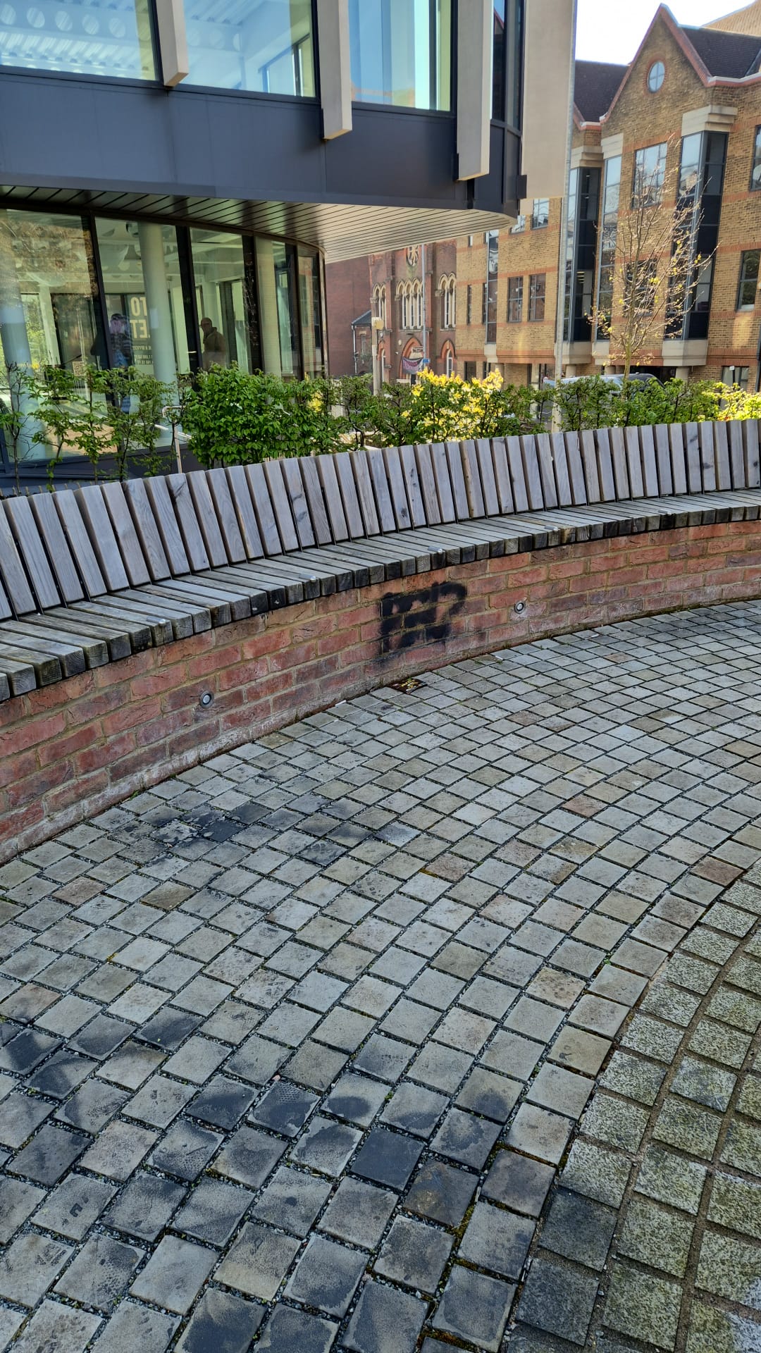 Commercial area with graffiti on brick planter wall before cleaning