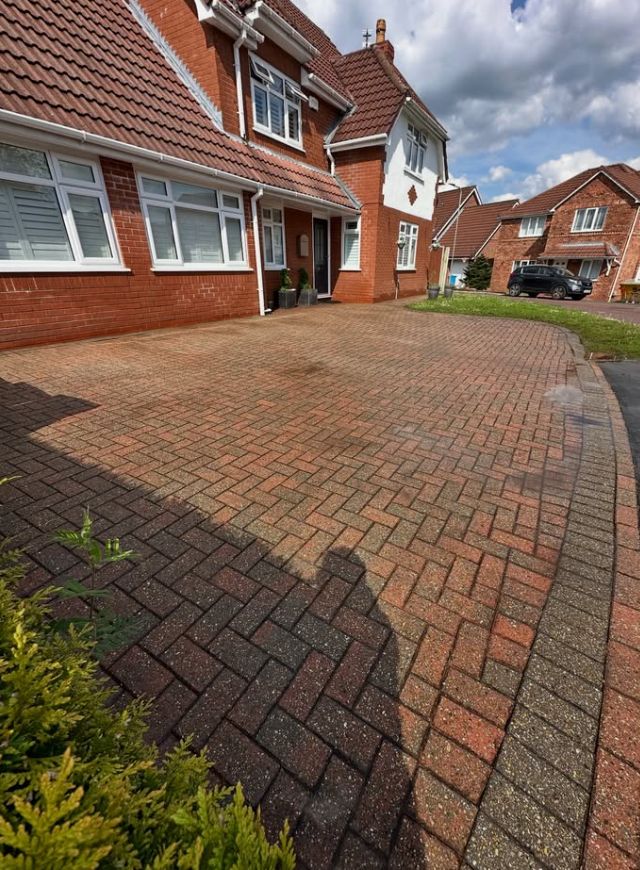 Clean red block paved driveway after professional exterior cleaning