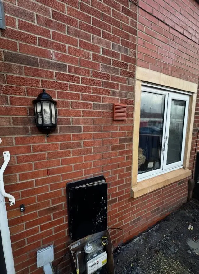 Brick wall restored after graffiti removal with original masonry colour revealed