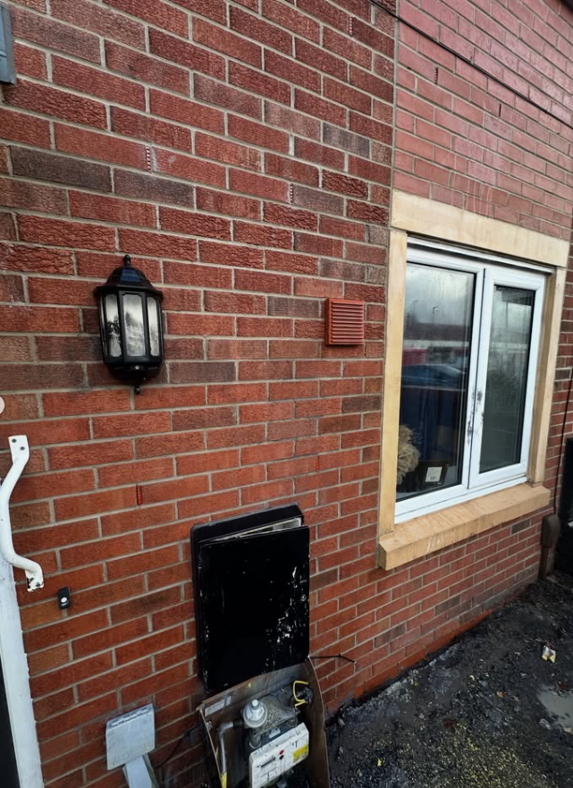 Brick wall restored after graffiti removal with original masonry colour revealed