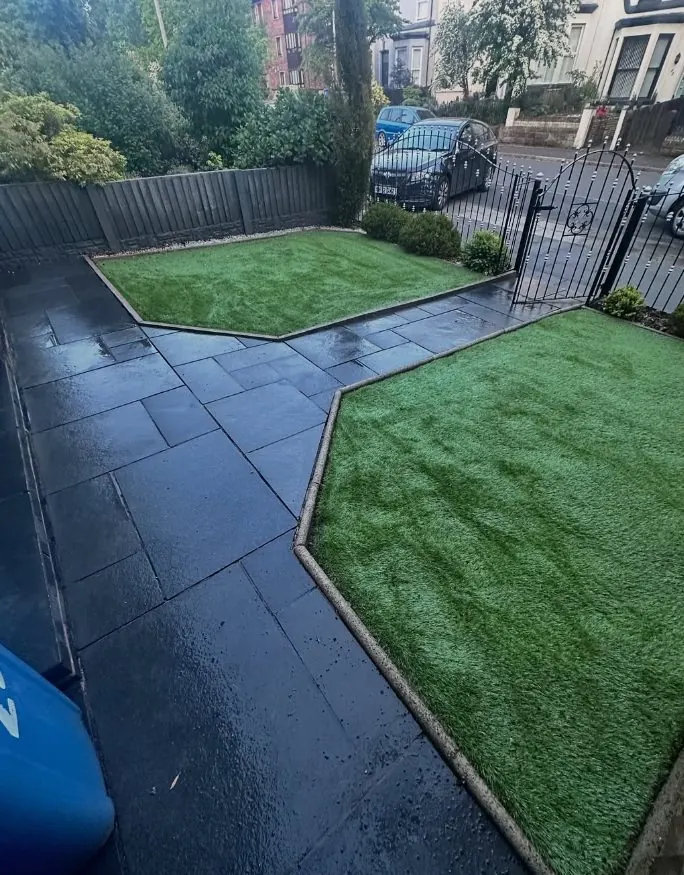Dark slate patio professionally cleaned with crisp edges next to green lawn