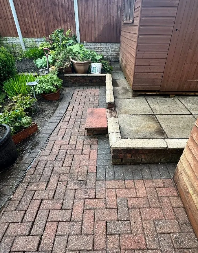 Cleaned block paved patio beside a garden shed after steam jet washing
