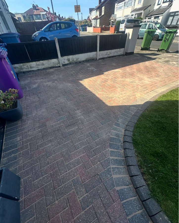 Professionally steam jet washed dark block paving commercial forecourt in Manchester