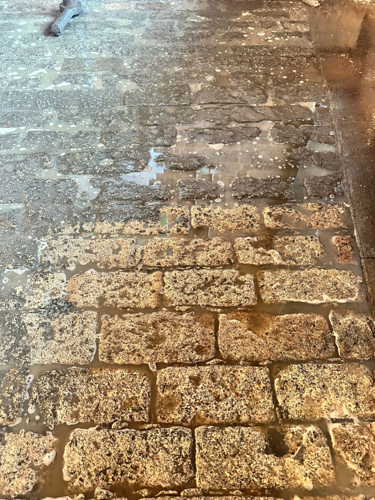 Close-up of cleaned cobblestone brickwork after DOFF steam treatment